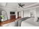 This main bedroom boasts wood floors, tray ceilings, a ceiling fan, and ensuite access to the bathroom at 260 Millstone Pkwy, Woodstock, GA 30188