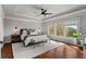 This spacious main bedroom features tray ceilings, a ceiling fan, large windows, and hardwood floors at 260 Millstone Pkwy, Woodstock, GA 30188