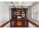 Sophisticated home office with a large wooden desk, built-in bookcase, and plantation shutters, creating a productive space at 260 Millstone Pkwy, Woodstock, GA 30188