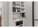 Pantry featuring white cabinets, granite countertops, a microwave, and herringbone tile backsplash at 260 Millstone Pkwy, Woodstock, GA 30188