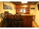 Basement bar with three black chairs, a wood bar, shelving, and decor at 3220 Warren Creek Dr, Powder Springs, GA 30127