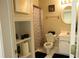 Bright bathroom featuring a toilet, vanity with sink, framed art, and built in storage shelving at 3220 Warren Creek Dr, Powder Springs, GA 30127