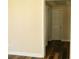Hallway with wood floors, base trim, tan walls, and a door leading to another room at 3220 Warren Creek Dr, Powder Springs, GA 30127