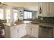 Kitchen island with sink and stainless steel dishwasher with view into the living room at 3220 Warren Creek Dr, Powder Springs, GA 30127
