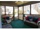 Screened porch with green flooring, wicker furniture, and wooded views at 3220 Warren Creek Dr, Powder Springs, GA 30127