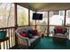 Inviting screened porch featuring comfortable wicker furniture and a mounted TV for outdoor enjoyment at 3220 Warren Creek Dr, Powder Springs, GA 30127