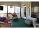Cozy screened porch with comfortable seating and a mounted television for outdoor entertainment at 3220 Warren Creek Dr, Powder Springs, GA 30127