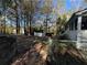 View of fenced backyard with outbuilding and surrounding trees, ideal for outdoor activities and storage at 695 Pine Shadows Dr, Dallas, GA 30157
