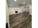 Bright living room features a stone fireplace, modern ceiling fan, and beautiful flooring adjacent to built-in cabinets at 695 Pine Shadows Dr, Dallas, GA 30157