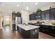 Stylish kitchen showcases dark cabinets, stainless steel appliances, and a granite island perfect for cooking at 161 Grace Cir, Acworth, GA 30102