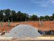 New construction site with pipes and gravel, set against a backdrop of lush trees and blue sky at 6348 Towhee Way, Morrow, GA 30260