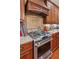 Close-up of a gas range in a kitchen with granite counters and custom cabinets at 19 Lindley Nw Ave, Marietta, GA 30064