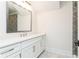 Well-lit bathroom with white vanity, decorative mirror, and modern shower at 220 Alcovy Terrace, Alpharetta, GA 30009