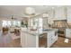 Open concept kitchen with island, stainless appliances, modern lighting, and seamless flow to living and dining area at 220 Alcovy Terrace, Alpharetta, GA 30009