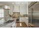 Bright kitchen featuring an island, stainless appliances, white cabinetry, and stylish lighting at 220 Alcovy Terrace, Alpharetta, GA 30009