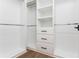 Bright walk-in closet with custom white shelving and drawers with black hardware at 220 Alcovy Terrace, Alpharetta, GA 30009