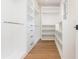 Bright walk-in closet with custom white shelving, drawers, and wood flooring at 220 Alcovy Terrace, Alpharetta, GA 30009