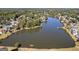 Aerial view of the community lake surrounded by trees and homes at 560 Hunt River Way, Suwanee, GA 30024