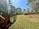 Expansive backyard with manicured lawn, mature trees, and a wooden deck at 560 Hunt River Way, Suwanee, GA 30024