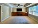 Finished basement with a large TV, built-in wooden cabinets, and large window at 560 Hunt River Way, Suwanee, GA 30024