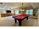 Finished basement with a pool table, TV, and built-in wooden cabinets at 560 Hunt River Way, Suwanee, GA 30024