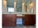 Bathroom with double sink vanity featuring granite countertops, dark wood cabinets, and wood look tile flooring at 560 Hunt River Way, Suwanee, GA 30024