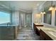 Bright bathroom featuring a double sink vanity, soaking tub, and large glass shower with wood look tile flooring at 560 Hunt River Way, Suwanee, GA 30024