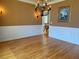 Dining room with hardwood floors, wainscoting, and a stylish chandelier, perfect for hosting gatherings at 560 Hunt River Way, Suwanee, GA 30024