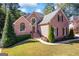 Charming brick home showcasing manicured lawn and attractive landscaping, with traditional architectural details at 560 Hunt River Way, Suwanee, GA 30024