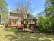 Beautiful home exterior with deck, surrounded by lush landscaping and mature trees providing a private backyard oasis at 560 Hunt River Way, Suwanee, GA 30024