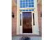 Close-up of elegant front door, framed by sidelights and decorative brickwork, leading into the home at 560 Hunt River Way, Suwanee, GA 30024