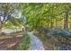 Beautifully landscaped stone path surrounded by lush greenery and trees at 560 Hunt River Way, Suwanee, GA 30024