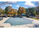 Community pool covered for the off-season, with playground and tennis courts in the background at 560 Hunt River Way, Suwanee, GA 30024