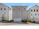 Modern three-story townhome with a two-car garage, neutral siding, and symmetrical window placement at 914 Martin Nw St, Atlanta, GA 30318