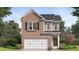 Charming brick home featuring a two-car garage, black shutters, and manicured landscaping at 12105 Conrad Cir, Hampton, GA 30228