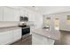 New kitchen with stainless appliances, center island, granite counters, and an adjacent living space at 12105 Conrad Cir, Hampton, GA 30228