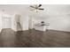 Open-concept living space features dark wood-look flooring, white walls, and a ceiling fan for a modern and airy feel at 12105 Conrad Cir, Hampton, GA 30228