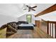 Attic space featuring wood floors, a sloped ceiling, a window, and comfortable seating furniture at 2775 Whippoorwill Cir, Duluth, GA 30097