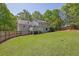 Large backyard with a wooden fence, lush green grass, and a spacious deck, perfect for entertaining or relaxing at 2775 Whippoorwill Cir, Duluth, GA 30097