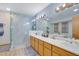 Modern bathroom featuring double sinks, wood cabinets, and a glass enclosed shower at 2775 Whippoorwill Cir, Duluth, GA 30097