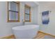 Bright bathroom featuring a modern soaking tub with wood-trimmed windows and a neutral color scheme at 2775 Whippoorwill Cir, Duluth, GA 30097
