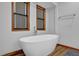 A modern white bathtub with a window view, complemented by wood-look flooring at 2775 Whippoorwill Cir, Duluth, GA 30097