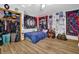 Unique bedroom featuring hardwood floors, open closet, and moon-themed wall art at 2775 Whippoorwill Cir, Duluth, GA 30097