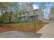 Beautiful home featuring stone accents, a chimney, a multi-level yard, and a long driveway leading to the residence at 2775 Whippoorwill Cir, Duluth, GA 30097