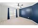 Spacious bedroom with blue accent wall, ceiling fan, plush carpet, and natural light from a window at 552 Lawton Bridge Sw Rd, Smyrna, GA 30082