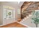 Bright entryway featuring hardwood floors, a staircase with iron railings, and decorative wood accent wall at 552 Lawton Bridge Sw Rd, Smyrna, GA 30082