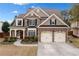 Beautiful home featuring stone and siding, a red front door, manicured landscaping, and a two car garage at 552 Lawton Bridge Sw Rd, Smyrna, GA 30082