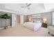 Spacious bedroom with tray ceilings, carpet, a ceiling fan, and many windows at 552 Lawton Bridge Sw Rd, Smyrna, GA 30082