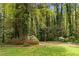 Lush backyard with mature trees, blooming flowers, and a well-kept lawn at 2350 Powers Ferry Se Dr, Marietta, GA 30067