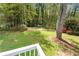 Grassy backyard featuring mature trees, colorful flower beds, and a clear view from the porch at 2350 Powers Ferry Se Dr, Marietta, GA 30067